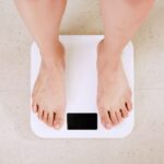 person standing on white digital bathroom scale